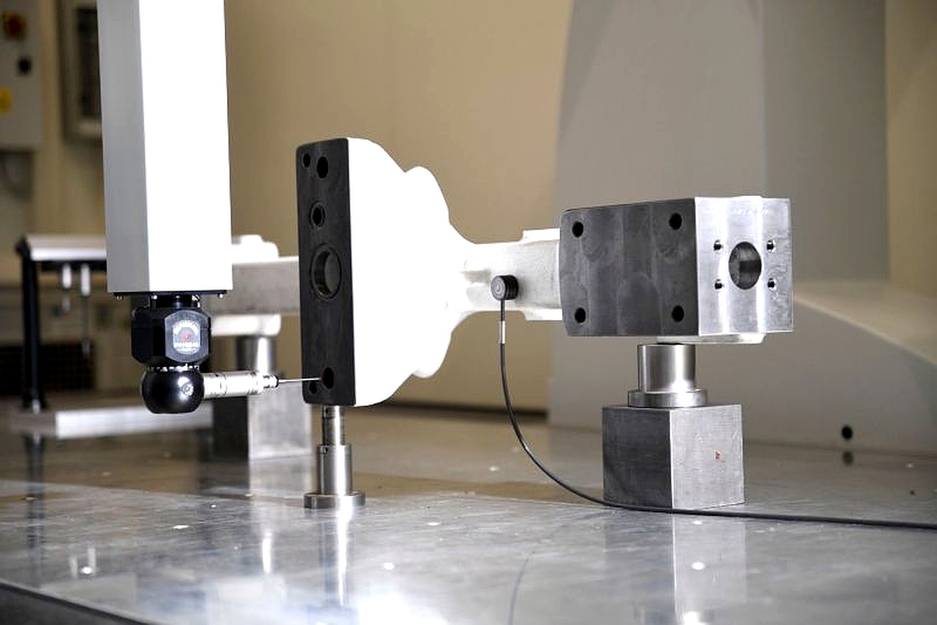 CMM probe inspecting a machined component with a calibration sphere