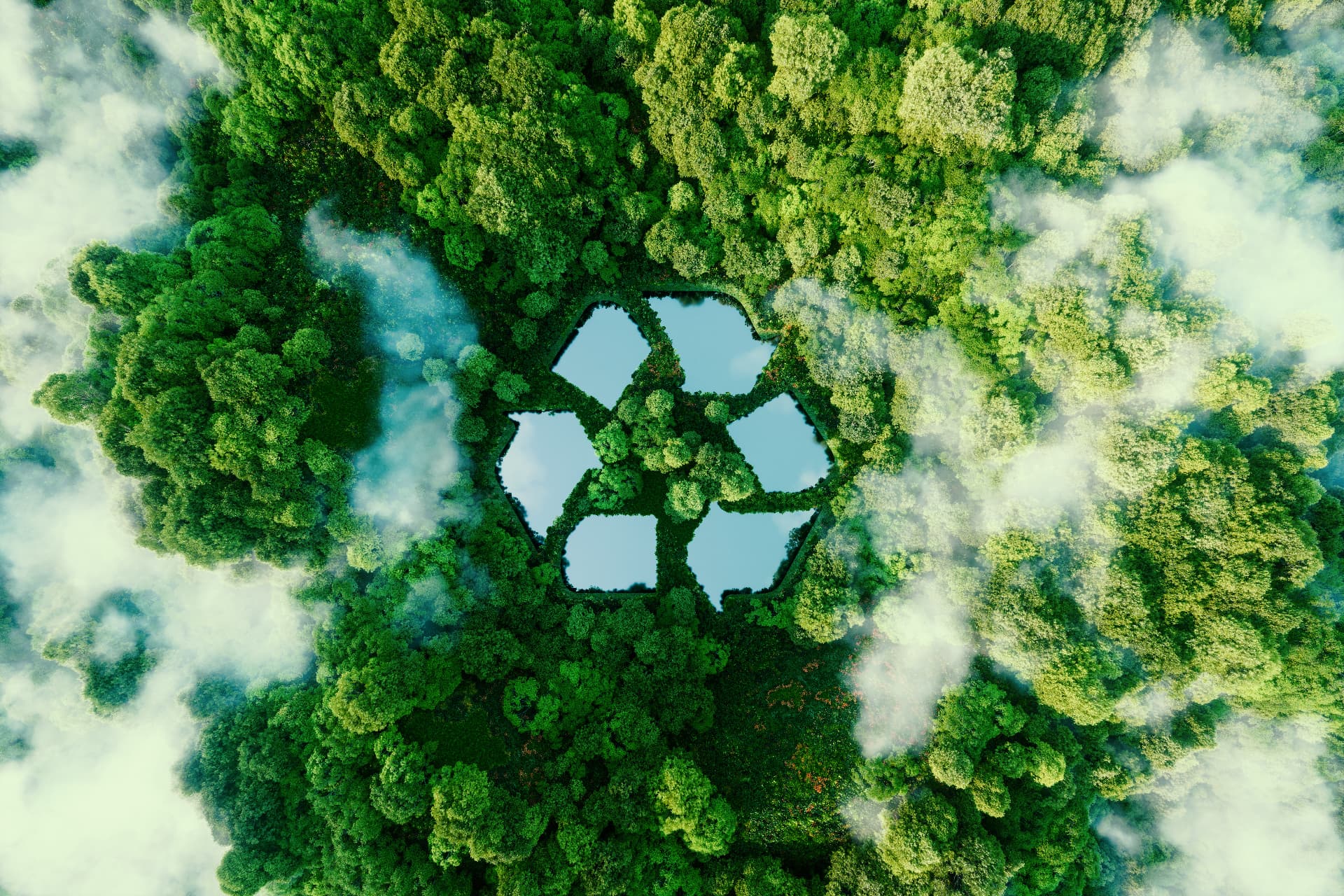 Aerial view of a forest with a lake shaped like the recycling symbol