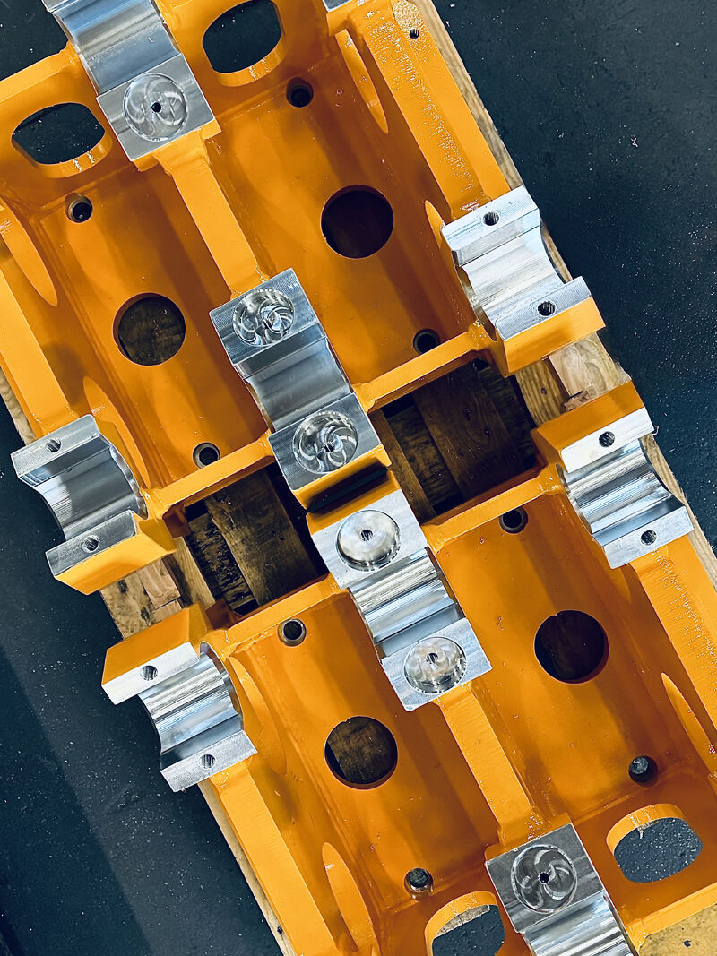Freshly painted machined components with fitted parts on a pallet