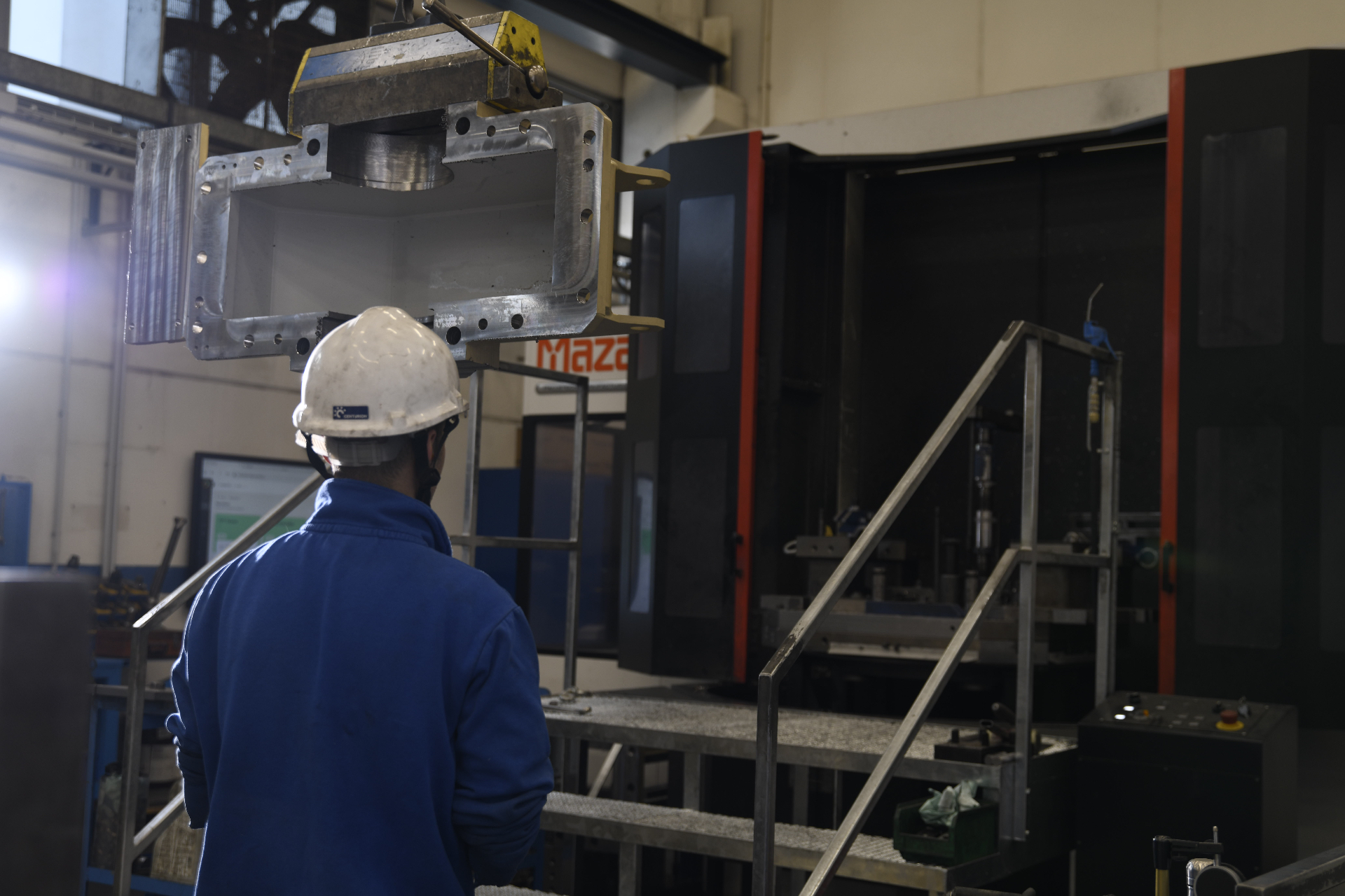 Pellanda operator positioning a machined housing at a CNC machine
